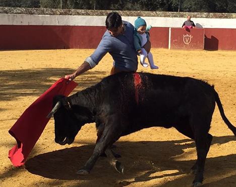 Torero mit fünf Monate alter Tochter auf dem Arm beim Stierquälen